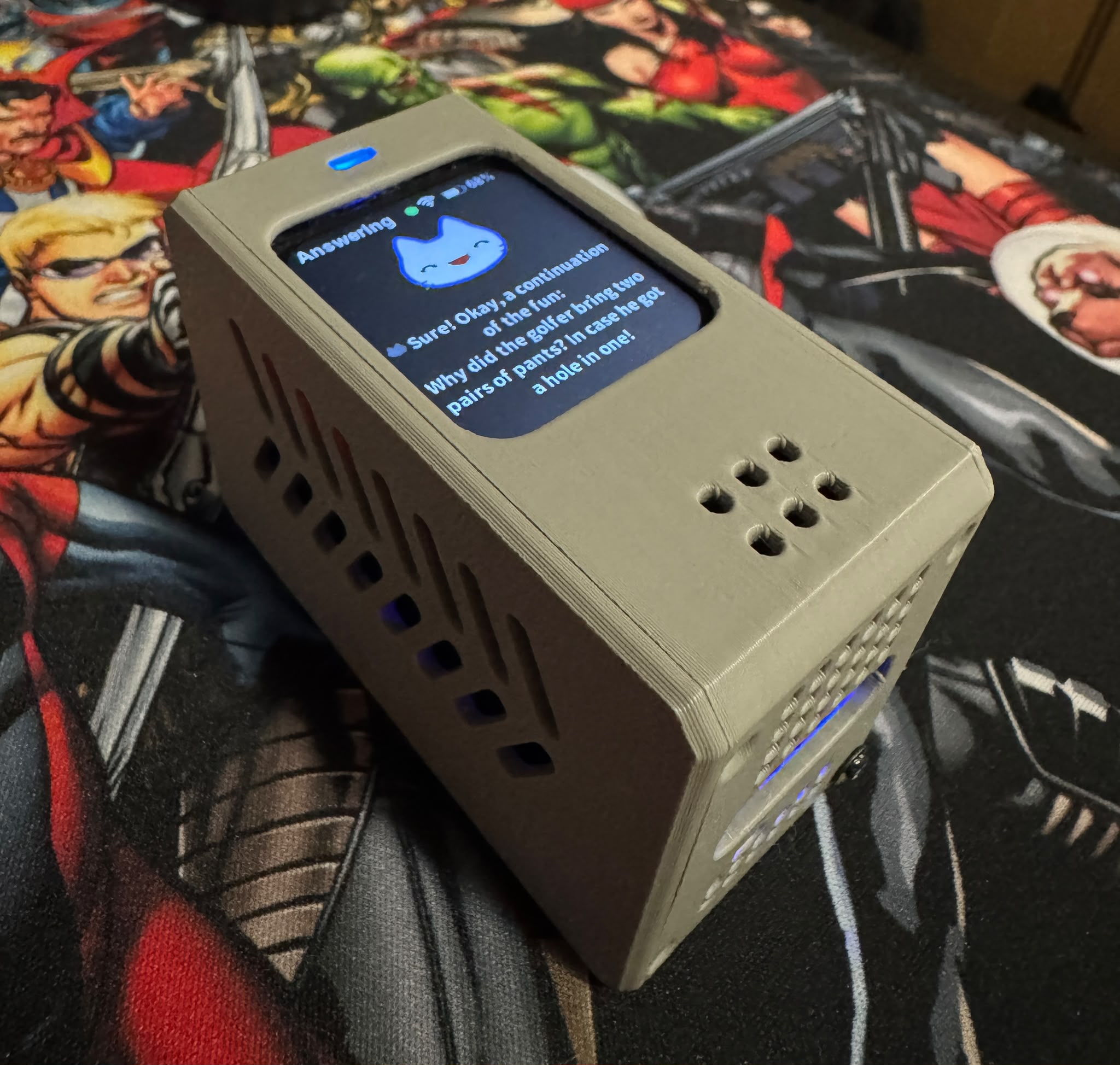 The assembled chatbot prototype in its 3D-printed enclosure, with a character and a conversational response on the display.